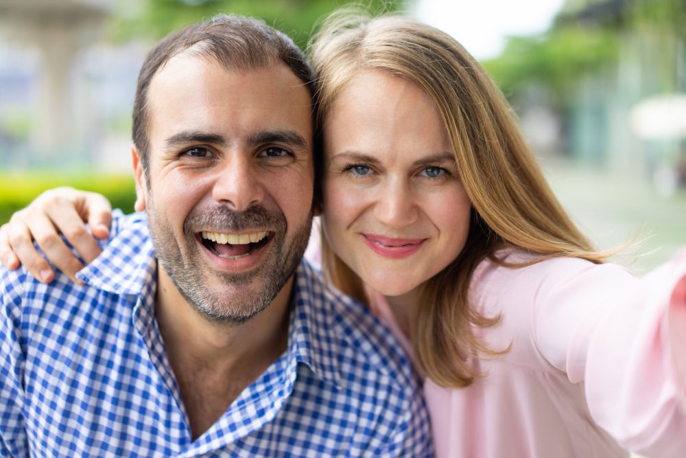 Smiling couple taking a selfie together outdoors